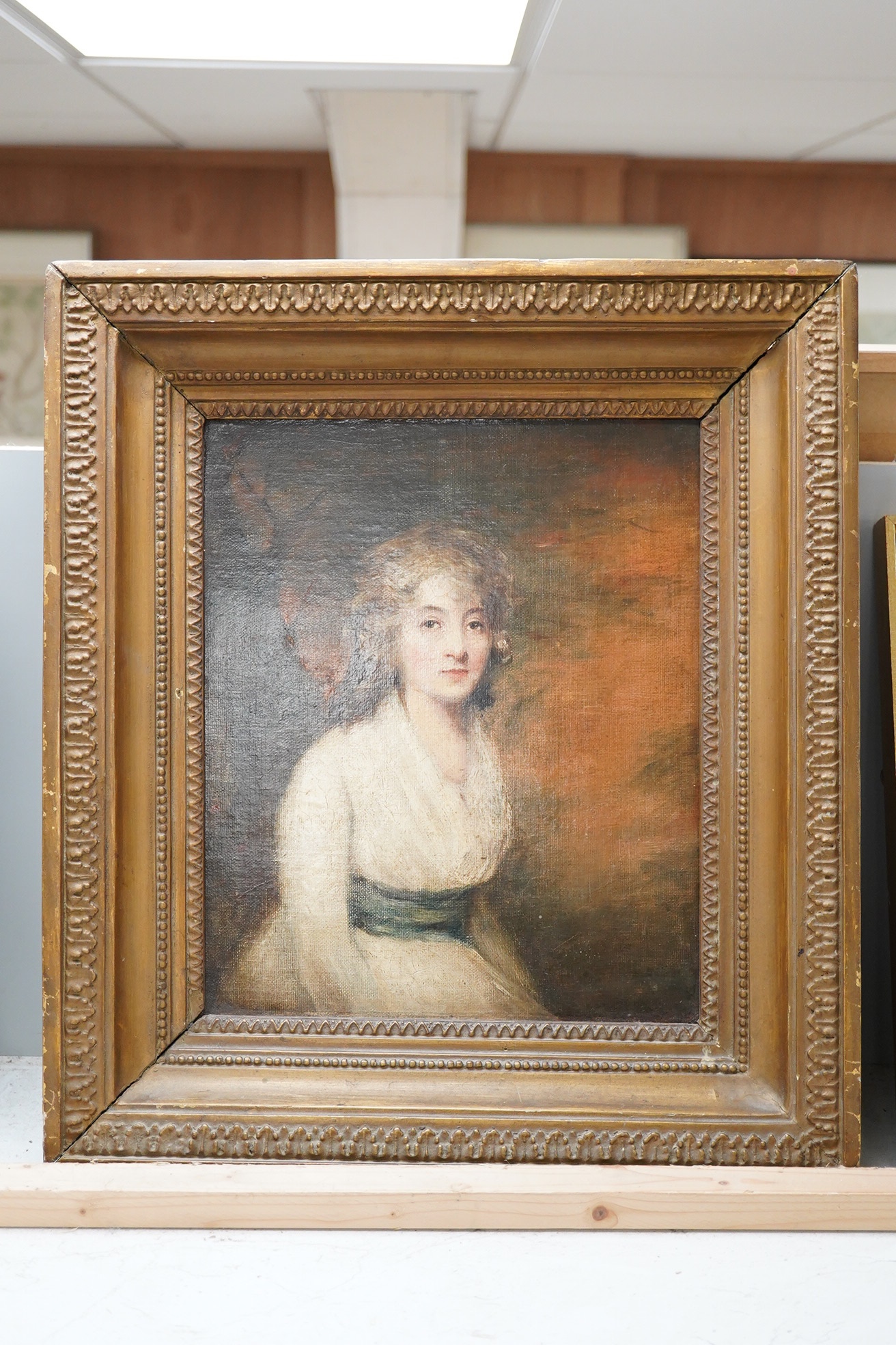 In the manner of George Romney (1734-1802), oil on canvas, Portrait of a Regency lady, unsigned, 30 x 24cm, ornately framed. Condition - poor to fair